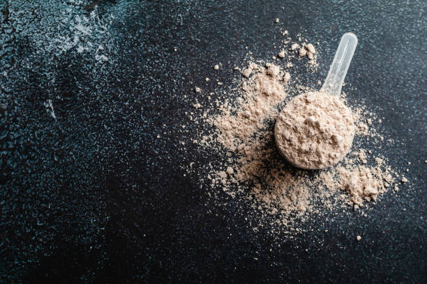 Top view of a whey protein concentrate on a dark background, copy space